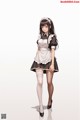 A woman in a maid outfit is posing for a picture.
