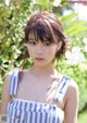 A woman in a blue and white striped dress posing for a picture.