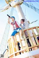 A couple of people sitting on top of a tall ship.